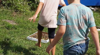 Die Feriendomizil-Kinder probieren den Barfußpfad aus, den sie selbst in ihrer „Welt der Sinne“ angelegt haben.