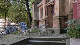 Im Schatten der Lutherkirche sind Stühle zum Ausruhen aufgestellt.