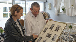 Kurt Oberfeld (Junior) zeigt Redakteurin Daniela Hoffmann alte Fotos aus der Geschichte von Eisdiele und Schokoladenhaus.