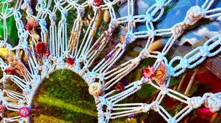 Strohblumen und gefärbte Gräser in einem Makramee.