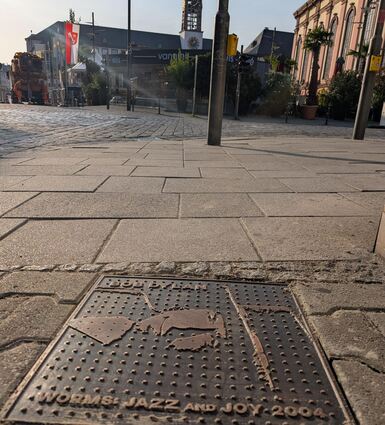 Bronzeplatten von neun Künstlern zieren jetzt das Straßenpflaster in Worms.
