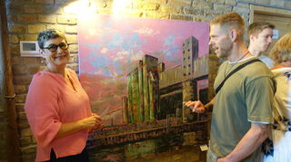 Eva Größler alias Lilac Titania vor ihrem Werk „Mühle Industriehafen Mannheim“ im Gespräch mit dem Grafitti-Künstler „Rise One“.