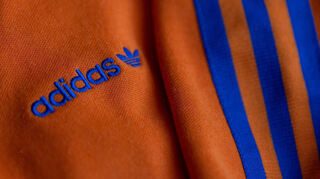 Das Logo des Sportartikelherstellers Adidas auf einer Jacke.