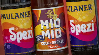 Spezi-Flaschen des Herstellers Paulaner, in der Mitte eine Flasche Mio Mio Cola-Orange-Mische des Herstellers Berentzen.