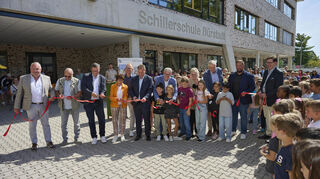Festliche Eröffnung mit Samtband-Zerstückelung: Mitmachen dürfen dabei auch Bärbel Schader (in Orange), die den Bau als Bürgermeisterin begleitet hat, sowie Nachfolger Boris Wenz (links daneben).
