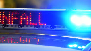Auf einem Polizeifahrzeug warnt eine Leuchtschrift vor einer Unfallstelle.