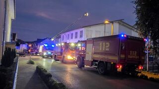Feuerwehrfahrzeuge stehen vor dem Supermarkt.