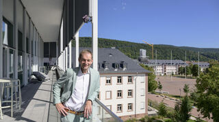 Hans-Jörg Kraus auf dem Balkon des H-Gebäudes, in dem sich früher der „War Room“ des US-Militärs befand. Im Hintergrund mit eingerüstetem Turm: das Torhaus.