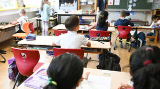 Schüler einer Grundschule sitzen in einer Schulstunde in ihrem Klassenzimmer.