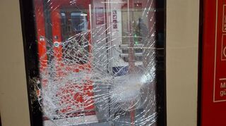 Eine durch Steinwurf beschädigte Scheibe einer Zugtür