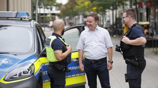 Ordnungsamtsleiter Christoph Winkler (M.) tauscht sich in der Fußgängerzone mit zwei Mitarbeitern der Stadtpolizei aus.