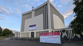 An der geschlossenen Hildegardkirche hängen Plakate, die auf das „Kirchenwandeln“ und die Ideensammlung zur künftigen Nutzung aufmerksam machen.