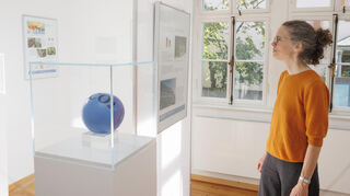 Museumsleiterin Elke Leinenweber schaut sich die Sonderausstellung „Klimagerecht leben“ an.