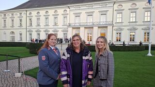 Gruppenfoto der drei Ehrenamtlichen aus der Metropolregion vor dem Schloss Bellevue in Berlin (v. l.): Sarah Marx, Martina Lenz und Fenja Tappe.
