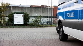 Ein Mannschaftswagen steht vor der JVA.