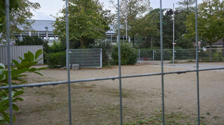HInter Gittern: der sogenannte Behelfsschulhof der Schule in den Weschnitzauen an der Riedhalle.