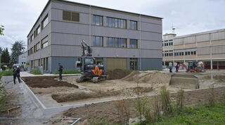 Das Außengelände um den Neubau soll laut Kreis erst nach den Herbstferien fertig sein. Ab November könne die Schule es nutzen. Rechts davon ist der Altbau zu sehen, der dann abgerissen wird.