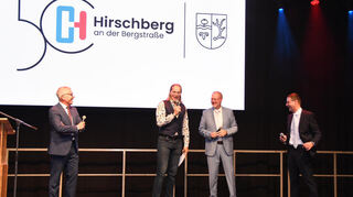 Beim Galaabend in der Heinrich-Beck-Halle unterhalten sich Landrat Stefan Dallinger, Chako Habekost, Bürgermeister Ralf Gänshirt und Weinheims Oberbürgermeister Manuel Just über das Jubiläum.