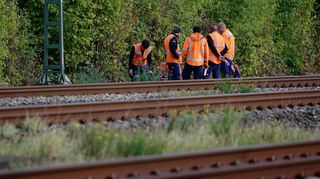 Bahn-Mitarbeiter stehen am Rand der Strecke Köln-Düsseldorf.