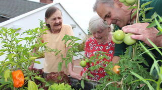 Caritasmitarbeiter Steffen Wenzel gärtnert mit Bewohnern von St. Elisabeth. Besonders groß ist die Freude, Tomaten und Paprika gedeihen zu sehen.