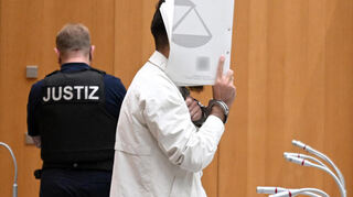 Sulaiman A., Angeklagter, steht im Gerichtssaal. Der Afghane A. hatte am 31. Mai 2024 auf dem Marktplatz in Mannheim fünf Teilnehmer einer Kundgebung der islamkritischen Bewegung Pax Europa sowie einen Polizisten mit einem Messer verletzt.