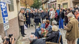 Zeitzeugin Ruth Steinfeld (sitzend, links) ist im Oktober 2024 Ehrengast bei der Verlegung von Stolpersteinen vor der früheren Synagoge.