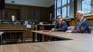 Kay Gottschalk (AfD, M), Bundestagsabgeordneter, sitzt mit Anwalt Michael Zischka (r) und Richter Burkhard Niebisch (hinten l) im Gerichtssaal.
