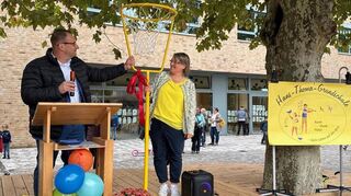 Bürgermeister Achim Weitz übergibt zur Einweihung des neugestalteten Schulhofs an der Hans-Thoma-Grundschule in Heddesheim einen Basketballkorb an Rektorin Dagmar Knispel.