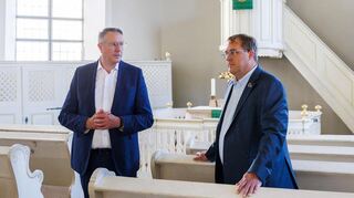 Alexander Schweitzer (SPD, l), Ministerpräsident von Rheinland-Pfalz und Thomas Jaworek (CDU), Kallstadter Ortsbürgermeister, sprechen miteinander in der Salvatorkirche von Kallstadt.