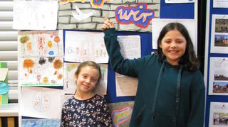 Maya (l.) und Johanna von der Schillerschule zeigen die Zukunftswand mit ihren Wünschen.