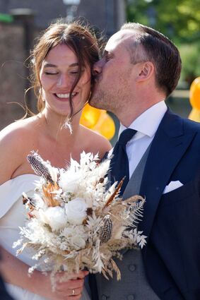 Nach der Hochzeit küsst Joe Laschet vor der Kirche seine Frau Andrea