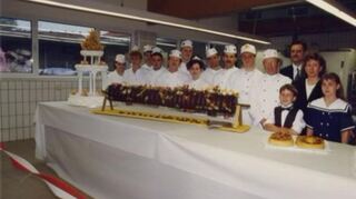 Ein Baumkuchen zur Eröffnung der Produktionsstätte in Worms. Rechts der jetzige Seniorchef Theodor Schmerker mit seiner Frau Renate sowie die Kinder Jasmin und Pascal.