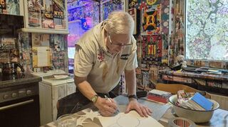 Hier zeigt der Ludwigshafener Willi Streily, wie er aus einem glitzernden Papierbogen einen Stern für seine Wand bastelt.