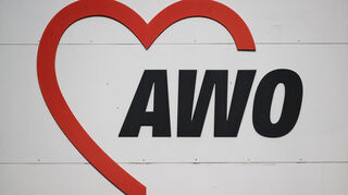 Das Logo der AWO, ein Wohlfahrtsverband in allen Bereichen sozialer Dienste, ist auf einem Schild zu sehen.