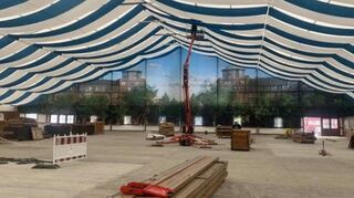 Der Aufbau läuft im Zelt für das Mannheimer Oktoberfest. Die Besucher blicken auf eine typische Mannheimer Stadtansicht: das Entrée zur Augustaanlage.