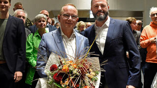 CDU-Wahlsieger Klaus Blettner (mit Blumenstrauß) nimmt die Gratulation seines SPD-Kontrahenten Jens Peter Gotter entgegen.