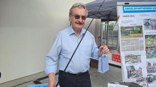 Rolf Sauer vom Angelsportverein und Gemeinderat lässt Besucher nach Süßigkeiten fischen