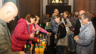 Der Förderverein der Apostelkirche in Viernheim schenkt anlässlich des Jubiläums Sekt aus.