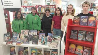 Julia Scheffler, die erste Vorsitzende der Sackschdoahogger Bürstadt, und Vizepräsidentin Marisa Scheffler begutachteten die Bücherspende für die Lampertheimer Bücherei zusammen mit Mitgliedern des Jugendbeirats.
