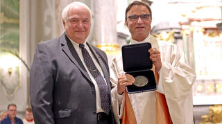 Zum Abschied die höchste Auszeichnung: Dekanatsratsvorsitzender Hansheinrich Beha (l.) überreicht Dekan Karl Jung in der Jesuitenkirche die Prälat-Bauer-Medaille.