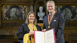 Die Rektorin der Universität Heidelberg, Frauke Melchior, überreicht Hanns-Peter Knaebel die Ernennungsurkunde und die Ehrensenator-Medaille.
