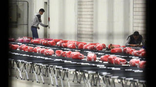 In den ehemaligen Lagerhallen der Spinelli-Kaserne werden 200 Personen pro Halle auf Feldbetten mit roten Schlafsäcken einquartiert.