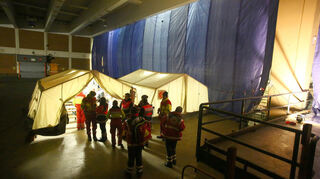 Johnaniter und Malteser sowie Polizisten nehmen in der alten Posthalle am Hauptbahnhof Flüchtlinge in Empfang und haben dafür in der Halle Zelte aufgebaut.