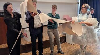 KI-Performance: Helen Piel (v.l.), Rudolf Seising, Pamela Pachl und die Künstlerin Janet Grau mit Endlospapier.