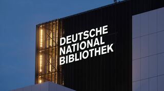 Der Schriftzug "Deutsche Nationalbibliothek" (DNB) leuchtet an einem 55 Meter hohen Gebäude der früheren Deutschen Bücherei. (Archivbild)
