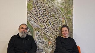 Das Künstlerduo Sourati: Mehrdad Zaeri und Christina Laube vor einem Luftbild der Rheinau.