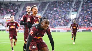 Glückliche Leipziger, vorne 1:0-Schütze Yan Diomande, jubeln in Augsburg.