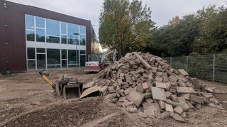 Noch prägen Baugeräte das Bild. In wenigen Wochen soll das Außengelände der Krippe in Ilvesheim fertig sein. Im Hintergrund ist der Anbau zu sehen, der sich nahtlos in die bestehende Gebäudestruktur (links außerhalb des Bildes und schräg rechts neben dem Baum) einfügt.