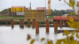 Der südlichste Pfeiler der Neckarbrücke (ganz hinten) am Ufer in Neckarhausen steht bereits, der zweite ist nahezu fertig. Die Stahlrohre im Fluss sind Teile eines Anprallschutzes, die Spundwände bilden später eine Baugrube im Neckar.