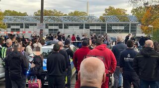 Schüler, Eltern und Lehrer sammeln sich am Mittwoch, 29. Oktober 2025, während des Amokalarms vor der Leichtathletikhalle in der Nähe des Südweststadions. Dort wurden die Schüler registriert.